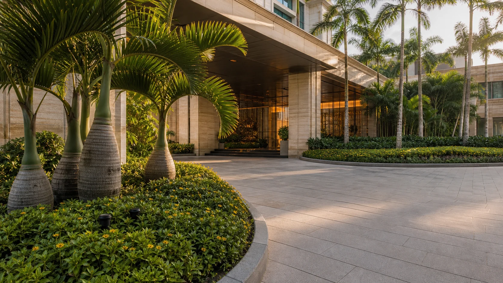 Luxury hotel arrival landscape with palms, layered planting beds, and polished guest approach design.