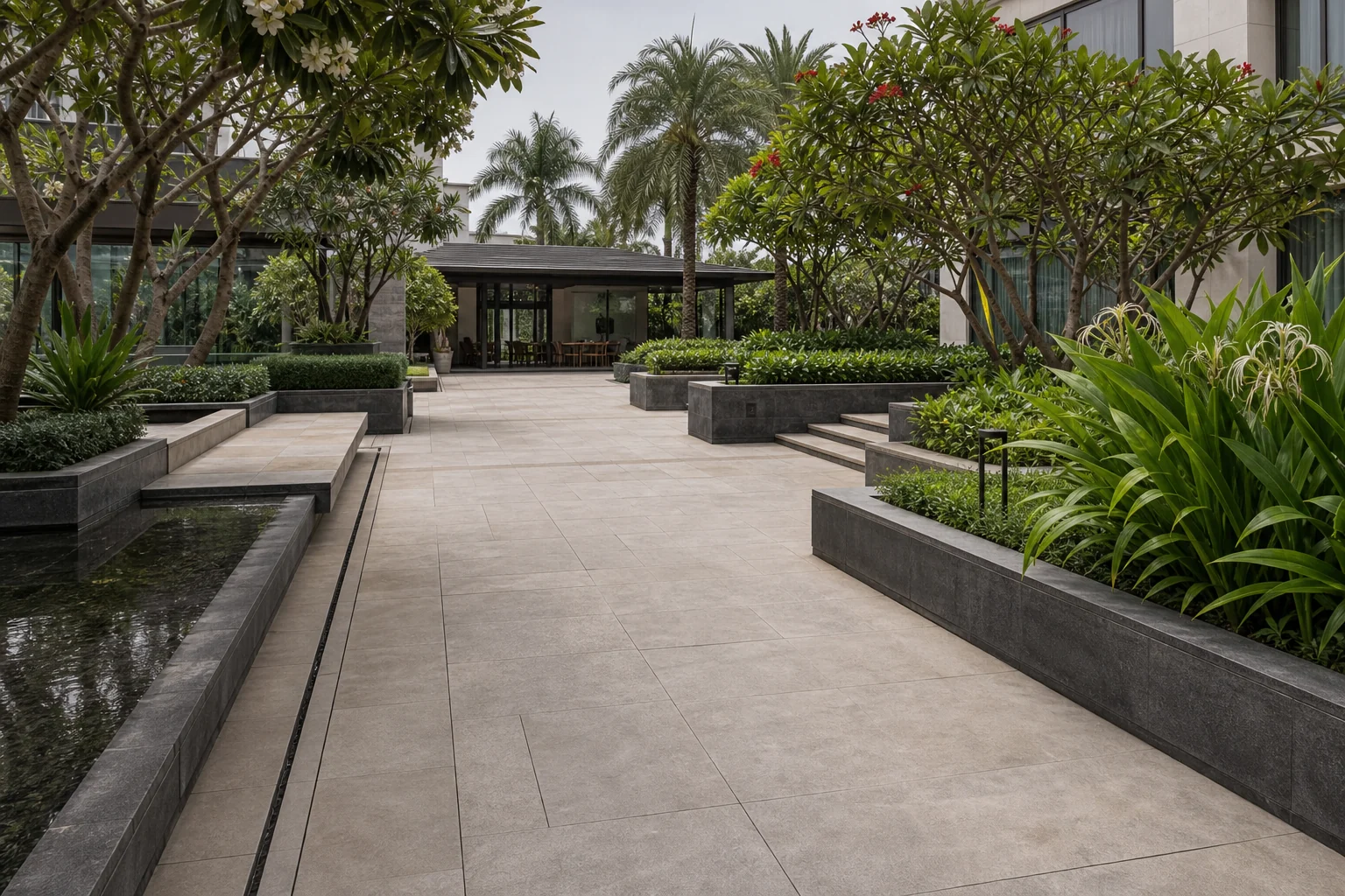 Commercial hardscape plaza with stone paving, clean planter edges, and shaded pedestrian circulation.